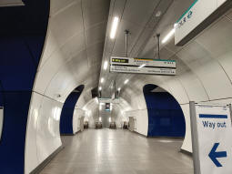 From the moving walkway to the Central line, Northern line platforms are to the left and right, the DLR is straight ahead
