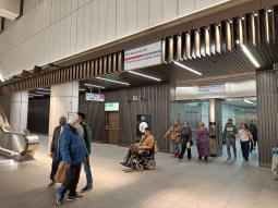 Left is the escalators up to the Davies Street ticket hall, behind is the escalators down to the Elizabeth line platforms (lift to both of these ahead-left), ahead is the tunnel to the Underground