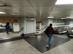 The escalator down to the Northern line northbound platform near some stairs up to the westbound District and Circle line platform and the escalator down to the Bakerloo line