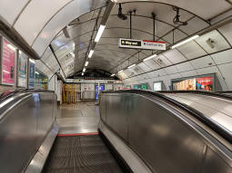 At the top of the escalators from the Piccadilly line. The escalators to continue up to the ticket hall are directly to the left
