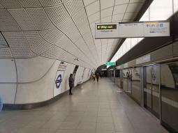 Elizabeth line eastbound, featuring a sign with arrows that can be turned on and off depending on which way they want you to go to the Northern line (straight on via the a deep-level passage, left via street level)
